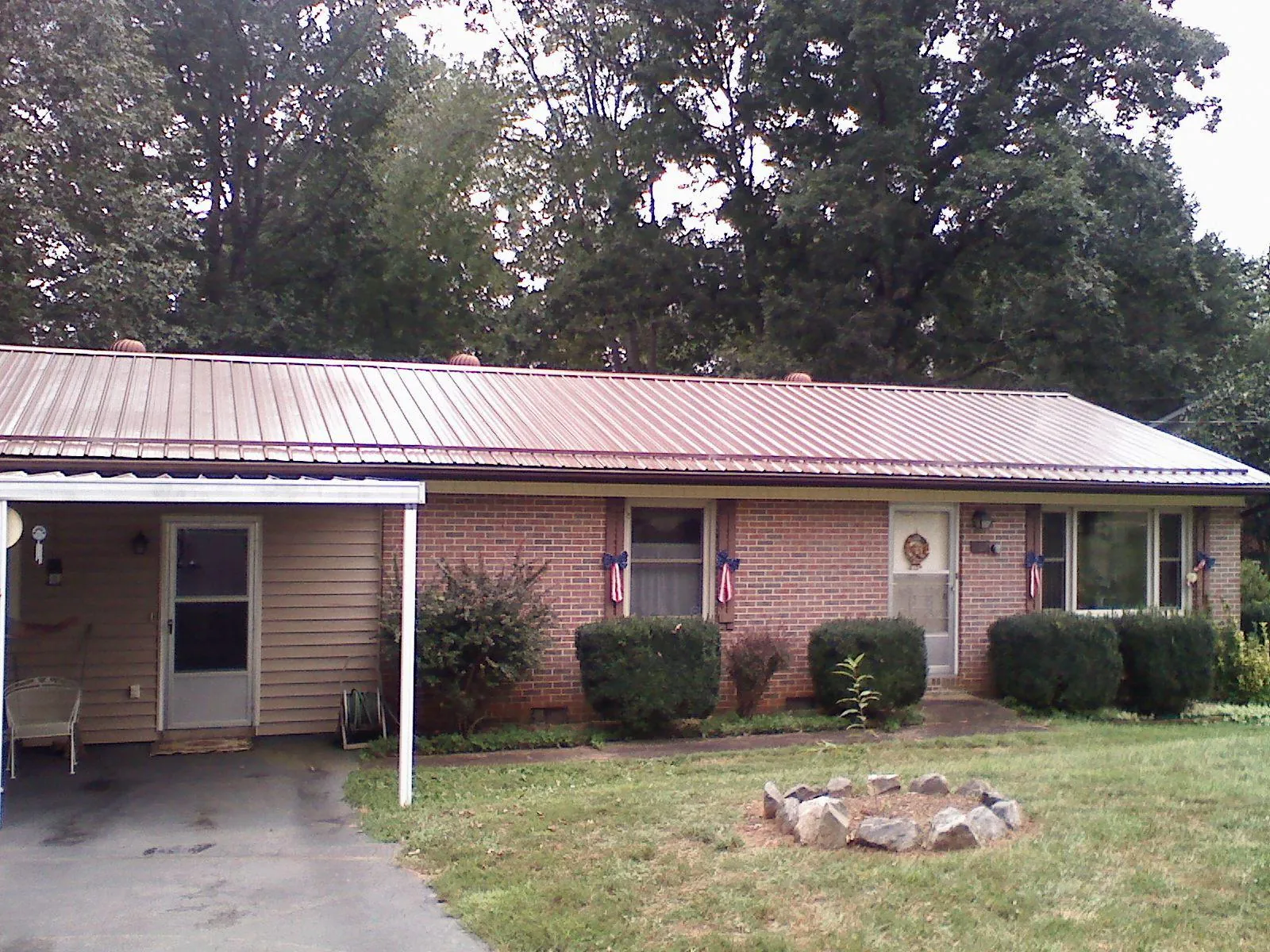 Bronze metal roof and carport on a brick ranch home — Roof Repair work by our crew in Ashburn